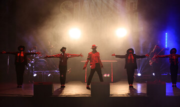 Michael Jackson tribute act Man in the Mirror with CJ centre stage with dancers either side.