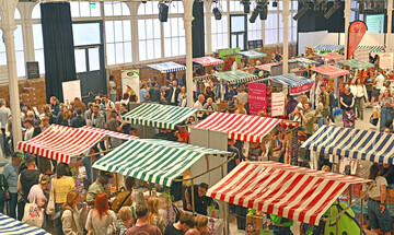 A view of the Fireworks Factory at Woolwich Works during Free From Festival, showing gluten-free food and drink stalls.