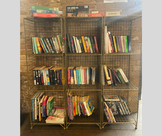 The rack of books and games at the Visitors' Book Cafe at Woolwich Works
