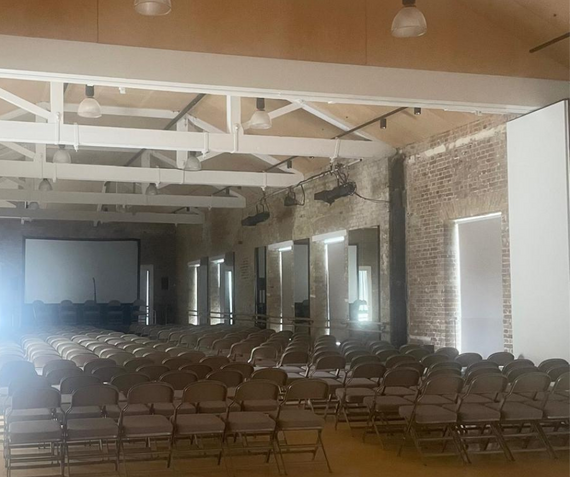 Inside Ropekeepers and Stonecutters Studios at Woolwich Works, set up with chairs and a large screen
