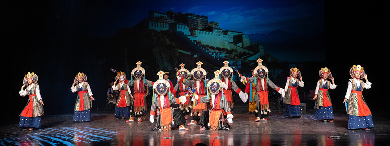 Members of the Tibetan Institute of Performing Arts performing on stage in traditional costume