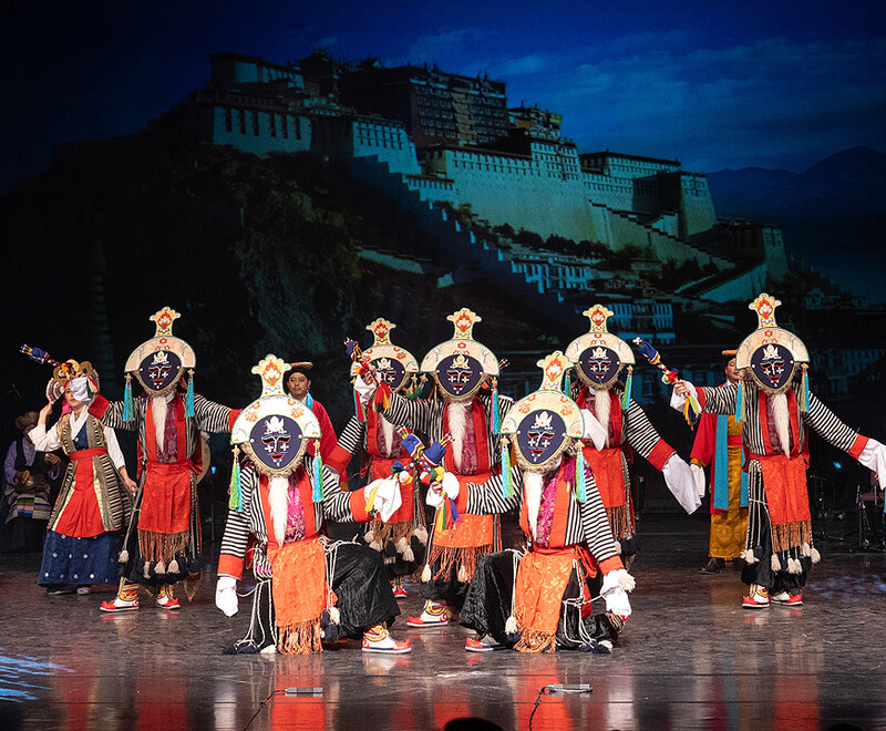 Members of the Tibetan Institute of Performing Arts performing on stage in traditional costume