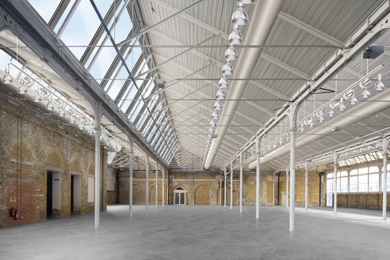 A render of the Fireworks Factory, a large space with a concrete floor, brick walls, and a metal and glass roof.