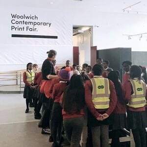 A photo of a group of children wearing school uniform and high-vis tabards gathered around a teacher.